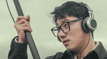 An individual holds recording equipment.